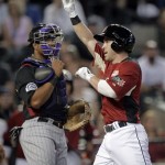 U.S. infielder Jason Kipnis, right, crosses home plate after hitting a solo home run as World catcher Wilin Rosario looks on during the first inning of the All-Star Futures baseball game Sunday, July 10, 2011, in Phoenix. (AP Photo/Matt York)
