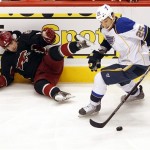 Phoenix Coyotes' David Schlemko, left, falls as St. Louis Blues' Chris Stewart moves the puck up ice during the first period of an NHL hockey game, Friday, Dec. 23, 2011, in Glendale, Ariz. (AP Photo/Matt York)