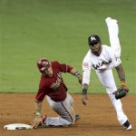 Arizona Diamondbacks' Gerardo Parra, left, is out at second base as Miami Marlins shortstop Jose Reyes, right, throws to first where Justin Upton was safe in the third inning during a baseball game in Miami, Sunday, April 29, 2012. (AP Photo/Lynne Sladky)