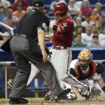 Arizona Diamondbacks' Aaron Hill, center, beats the throw to Miami Marlins catcher John Buck, right, to score on a single hit by Willie Bloomquist in the sixth inning during a baseball game in Miami, Sunday, April 29, 2012. The Diamondbacks defeated the Marlins 8-4. (AP Photo/Lynne Sladky)