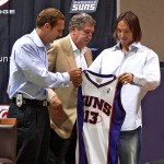 Newly aquired Phoenix Suns guard Steve Nash, right, holds up his new jersey as Suns President Bryan Colangelo, left, and CEO Jerry Colangelo watch Wednesday, July 14, 2004, at America West Arena in Phoenix. Nash, who was originally signed by the Suns in 1996, returns to Phoenix after spending six seasons in Dallas. (AP Photo/Matt York)

