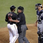 Arizona Diamondbacks' Justin Upton (10) is held back by home plate 
umpire Derryl Cousins as Milwaukee Brewers catcher Jonathan Lucroy 
watches after Upton was hit by a pitch during the third inning of a 
baseball game, Saturday, May 26, 2012, in Phoenix. (AP Photo/Matt 
York)