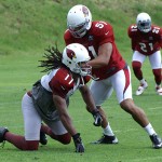 Larry Fitzgerald slips on the ground in front of Paris Lenon during 
training camp in Flagstaff on July 31, 2012. (Adam Green/Arizona 
Sports)