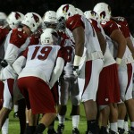 John Skelton and the Cardinals huddle up during the team's annual 
night practice at Lumberjack Stadium on August 1, 2012. (Adam 
Green/Arizona Sports)