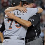 Umpire crew chief Jim Joyce embraces Miami Marlins bullpen catcher Jeff Urgelles (75) prior to the Marlins' game against the Arizona Diamondbacks, Wednesday, Aug. 22, 2012, in Phoenix. Joyce happened to be walking past Jayne Powers when she collapsed before Monday night's game between the two teams. After deciding it wasn't a seizure, as some of her co-workers suggested, Joyce quickly started CPR. Marlins bullpen catcher Urgelles, a former firefighter and paramedic, was called to the scene and began helping Joyce. Paramedics arrived moments later and transported the woman to a hospital, where her condition improved. (AP Photo/Matt York)