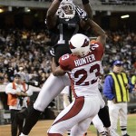 Oakland Raiders' receiver Mike Williams, top, hauls in a touchdown pass over Arizona Cardinals cornerback Darrell Hunter during the first half. (AP Photo/Marcio Jose Sanchez)