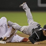 Colorado Rockies second baseman Kazuo Matsui is tripped up by Arizona Diamondbacks' Mark Reynolds as he turns a double play on a ball hit by Chris Snyder during the fourth inning in Game 1 of the National League Championship baseball series in Phoenix, Thursday. (AP Photo/David J. Phillip)