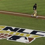 A worker sweeps the first base line before the start of Game 1 of the National League Championship baseball series between the Colorado Rockies and Arizona Diamondbacks in Phoenix, Thursday. (AP Photo/Ross D. Franklin)