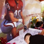 Fans sign a memorial for former Arizona Cardinals and U.S. Army Ranger Pat Tillman Friday, April 23, 2004 at the Cardinals training facility in Tempe, Ariz. Tillman was killed in Afghanistan after walking away from a multimillion-dollar NFL contract to join the Army Rangers, U.S. officials said Friday. Tillman played four seasons with the Cardinals before enlisting in the Army in May 2002. The safety turned down a three-year, $3.6 million deal from Arizona. (AP Photo/Matt York)