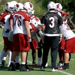 Carson Palmer huddles up with the team during voluntary veterans mini-camp at the team's Tempe training facility on April 23, 2013. (Adam Green/Arizona Sports)