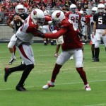 Quarterback Carson Palmer drops back to pass while receiver Michael Floyd and defensive back Patrick Peterson battle during the Cardinals' Red & White Practice Saturday, August 3 at University of Phoenix Stadium in Glendale. (Adam Green/Arizona Sports)