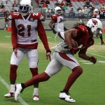 Receiver Larry Fitzgerald runs by Patrick Peterson after making a catch during Arizona Cardinals training camp Tuesday, Aug. 13 at University of Phoenix Stadium in Glendale. (Adam Green/Arizona Sports)