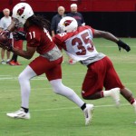 Receiver Larry Fitzgerald makes a reception as Javier Arenas defends during Arizona Cardinals training camp on Aug. 19, 2013 at University of Phoenix Stadium in Glendale. (Adam Green/Arizona Sports)
