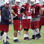Coach Bruce Arians instructs his team while tight end Rob Housler (84) as well as linemen Eric Winston (65) and Daryn Colleged (71) look on during Arizona Cardinals training camp at University of Phoenix Stadium on Aug. 22, 2013. (Adam Green/Arizona Sports)