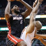 Miami Heat's LeBron James (6) scores against Phoenix Suns' P.J. Tucker, right, during the first half of an NBA basketball game, Tuesday, Feb. 11, 2014, in Phoenix. (AP Photo/Ross D. Franklin)