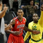 Arizona's Rondae Hollis-Jefferson, center, reacts to an official's call as Oregon's Jason Calliste, left, mirrors the call on an out-of-bounds play that went in favor of the Ducks during the first half of an NCAA college basketball game in Eugene, Ore. on Saturday, March 8, 2014. (AP Photo/Chris Pietsch)