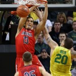 Arizona's Nick Johnson, left, slams a dunk over teammate Kaleb Tarczewski and Oregon's Waverly Austin during the first half of an NCAA college basketball game in Eugene, Ore. on Saturday, March 8, 2014. (AP Photo/Chris Pietsch)