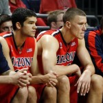 Arizona's Elliot Pitts, center left, and Kaleb Tarczewski, center right, watch from the bench as Oregon moves ahead in the second half of an NCAA college basketball game in Eugene, Ore. on Saturday, March 8, 2014. (AP Photo/Chris Pietsch)