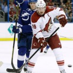 Phoenix Coyotes right wing Shane Doan (19) looks to deflect the puck as he stands in front of Tampa Bay Lightning defenseman Matt Carle (25) during the first period of an NHL hockey game, Monday, March 10, 2014, in Tampa, Fla. (AP Photo/Chris O'Meara)