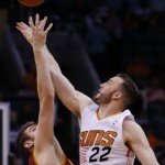 Phoenix Suns' Miles Plumlee (22) beats Cleveland Cavaliers' Spencer Hawes for a jump ball during the first half of an NBA basketball game on Wednesday, March 12, 2014, in Phoenix. (AP Photo/Ross D. Franklin)