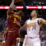 Cleveland Cavaliers' Kyrie Irving (2) is fouled by Phoenix Suns' Gerald Green (14) during the first half of an NBA basketball game on Wednesday, March 12, 2014, in Phoenix. (AP Photo/Ross D. Franklin)