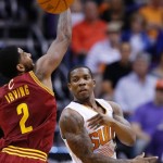 Phoenix Suns' Eric Bledsoe, right, passes around the defense of Cleveland Cavaliers' Kyrie Irving (2) during the first half of an NBA basketball game on Wednesday, March 12, 2014, in Phoenix. (AP Photo/Ross D. Franklin)