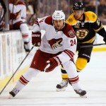 Phoenix Coyotes center Kyle Chipchura (24) skates past Boston Bruins' Chris Kelly during the first period of an NHL hockey game in Boston Thursday, March 13, 2014. (AP Photo/Winslow Townson)