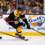 Boston Bruins' Milan Lucic (17) looks for an opening around Phoenix Coyotes defenseman Oliver Ekman-Larsson (23) during the second period of an NHL hockey game in Boston Thursday, March 13, 2014. (AP Photo/Winslow Townson)