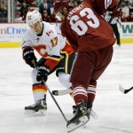 Calgary Flames' Lance Bouma (17) and Phoenix Coyotes' Mike Ribeiro (63) battle for the puck during the first period of an NHL hockey game on Saturday, March 15, 2014, in Glendale, Ariz. (AP Photo/Matt York)