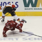 Calgary Flames' Mark Giordano, top, trips Phoenix Coyotes' Radim Vrbata (17) for a penalty during the second period of NHL hockey game, Saturday, March 15, 2014, in Glendale, Ariz. (AP Photo/Matt York)