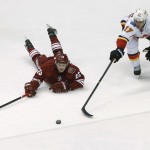 Calgary Flames' Lance Bouma (17) and Phoenix Coyotes' Oliver Ekman-Larsson (23) chase down the puck during the third period of an NHL hockey game, Saturday, March 15, 2014, in Glendale, Ariz. The Coyotes won 3-2. (AP Photo/Matt York)