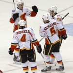 Calgary Flames' Sean Monahan (23), Kris Russell (4), Mark Giordano (5) and Curtis Glencross (20) celebrate a goal against the Phoenix Coyotes during the second period of NHL hockey game, Saturday, March 15, 2014, in Glendale, Ariz. (AP Photo/Matt York)