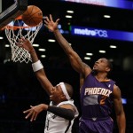 Brooklyn Nets's Paul Pierce, left, puts up a shot while Phoenix Suns' Eric Bledsoe defends during the first half of the NBA basketball game at the Barclays Center Monday, March 17, 2014 in New York. (AP Photo/Seth Wenig)