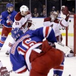New York Rangers' Derick Brassard (16), front, scores on Phoenix Coyotes goalie Mike Smith, right, during the second period of the NHL hockey game, Monday, March 24, 2014, in New York. (AP Photo/Seth Wenig)
