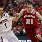 Wisconsin 's Josh Gasser (21) tries to drive past Arizona's Gabe York (1) during the first half in a regional final NCAA college basketball tournament game, Saturday, March 29, 2014, in Anaheim, Calif. (AP Photo/Jae C. Hong)