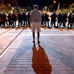 A lone man confronts a line of Tucson Police Department officers after Arizona's 64-63 loss to Wisconsin Saturday night. (Photo by Kelly Presnell/Daily Star)