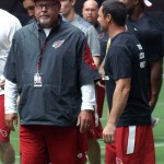 Cardinals coach Bruce Arians talks with kicker Jay Feely before the conditioning test at University of Phoenix Stadium in Glendale, Ariz, on July 25. (Adam Green/Arizona Sports)