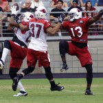 Cornerback Teddy Williams comes down with an interception in front of receiver Jaron Brown and safety Anthony Walters during Arizona Cardinals training camp Aug. 7, 2014. (Photo: Adam Green/Arizona Sports)