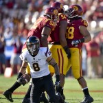 Southern California defensive tackle Delvon Simmons (52), defensive end Leonard Williams (94) and linebacker J.R. Tavai (58) celebrate after holding Arizona State running back D.J. Foster (8) to a loss during the first half of an NCAA college football game, Saturday, Oct. 4, 2014, in Los Angeles. (AP Photo/Gus Ruelas)