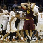Texas players celebrate Cameron Ridley's game winning shot as Arizona State center Jordan Bachynski (13) walks off after a second-round game in the NCAA college basketball tournament Thursday, March 20, 2014, in Milwaukee. Texas won 87-85. (AP Photo/Jeffrey Phelps)