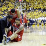 In this Saturday, Feb. 1, 2014, photo, Arizona's Brandon Ashley, bottom right, is examined as teammate Nick Johnson (13) watches after Ashley went down with an injury during an NCAA college basketball game against California in Berkeley, Calif. Arizona now faces playing the rest of the season without one of its best, most versatile players. (AP Photo/Marcio Jose Sanchez)
