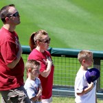 A family stands together, hands over their hearts, for the playing of the National Anthem before a Spring Training game. Photo by Zachary Holland/Cronkite News