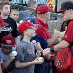 A young fan gets his baseball signed by Chris Owings before a Spring Training game. Photo by Zachary Holland/Cronkite News