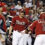 After hitting a home run, Arizona Diamondbacks' Welington Castillo (7) shakes hands with Nick Ahmed, middle, as Los Angeles Angels' Chris Iannetta, left, looks to the infield during the fourth inning of a baseball game Wednesday, June 17, 2015, in Phoenix. (AP Photo/Ross D. Franklin)