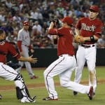 Arizona Diamondbacks' David Hernandez, middle, makes a catch on a bunt attempt by Los Angeles Angels' Erick Aybar as Diamondbacks' Welington Castillo, left, and Aaron Hill, right, close induring the seventh inning of a baseball game Wednesday, June 17, 2015, in Phoenix. (AP Photo/Ross D. Franklin)