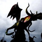 A man carries an Alebrije on his head during a parade in Mexico City, Saturday, Oct. 20, 2007. Alebrijes are brightly-colored Mexican folk art sculptures of fantastical animal-like creatures. (AP Photo/Eduardo Verdugo)