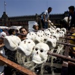 Workers carry an artwork with fake skulls to be placed in Mexico City's Zocalo plaza during preparing for Day of the Dead festivities, Wednesday, Oct. 31, 2007. Altars and artwork from around the country were on display Wednesday in the Zocalo, as Mexicans honor Day of the Dead. (AP Photo/Eduardo Verdugo)