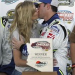 Jimmie Johnson, right, get a kiss from his wife, Chandra Johson, after his win in the NASCAR Nextel Cup Series' Checker Auto Parts 500 auto race at Phoenix International Raceway on Sunday, Nov. 11, 2007, in Avondale, Ariz. (AP Photo/Rick Scuteri)