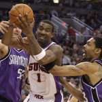 Phoenix Suns center Amare Stoudemire, center, grabs an offensive rebound between Sacramento Kings center Brad Miller, left, and Mikki Moore, right, in the third quarter of an NBA basketball game Wednesday, Nov. 21, 2007, in Phoenix. (AP Photo/Paul Connors)