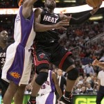 Miami Heat guard Dwayne Wade drives past Phoenix Suns Amare Stoudemire for two during the first quarter of an NBA basketball game Monday. (AP Photo/Matt York)